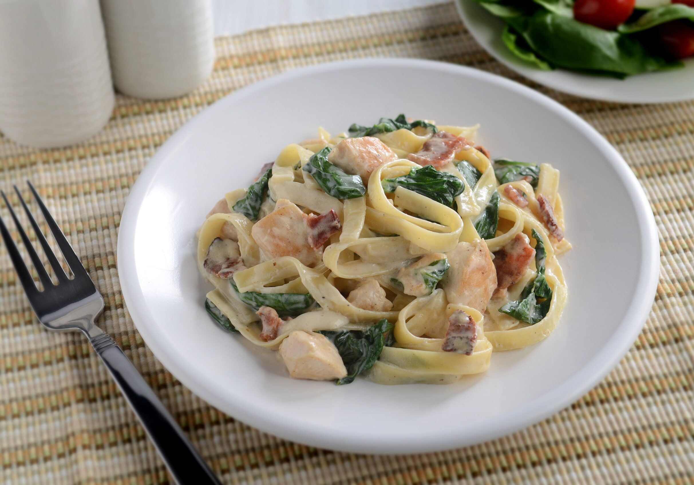 Linguine with bacon, Alfredo sauce, diced chicken, fresh spinach, and Parmesan cheese
