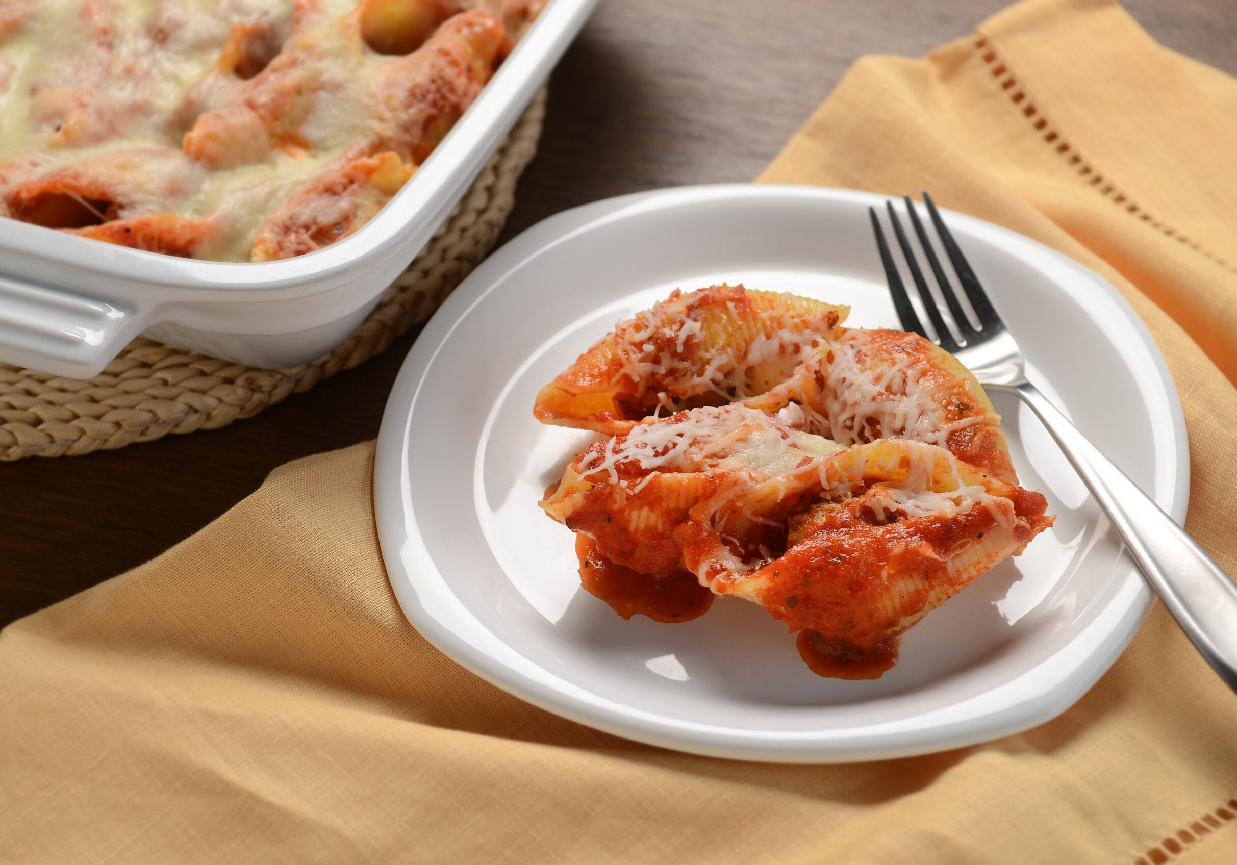 Meatball stuffed shells coated in marinara sauce, topped with shredded mozzarella cheese