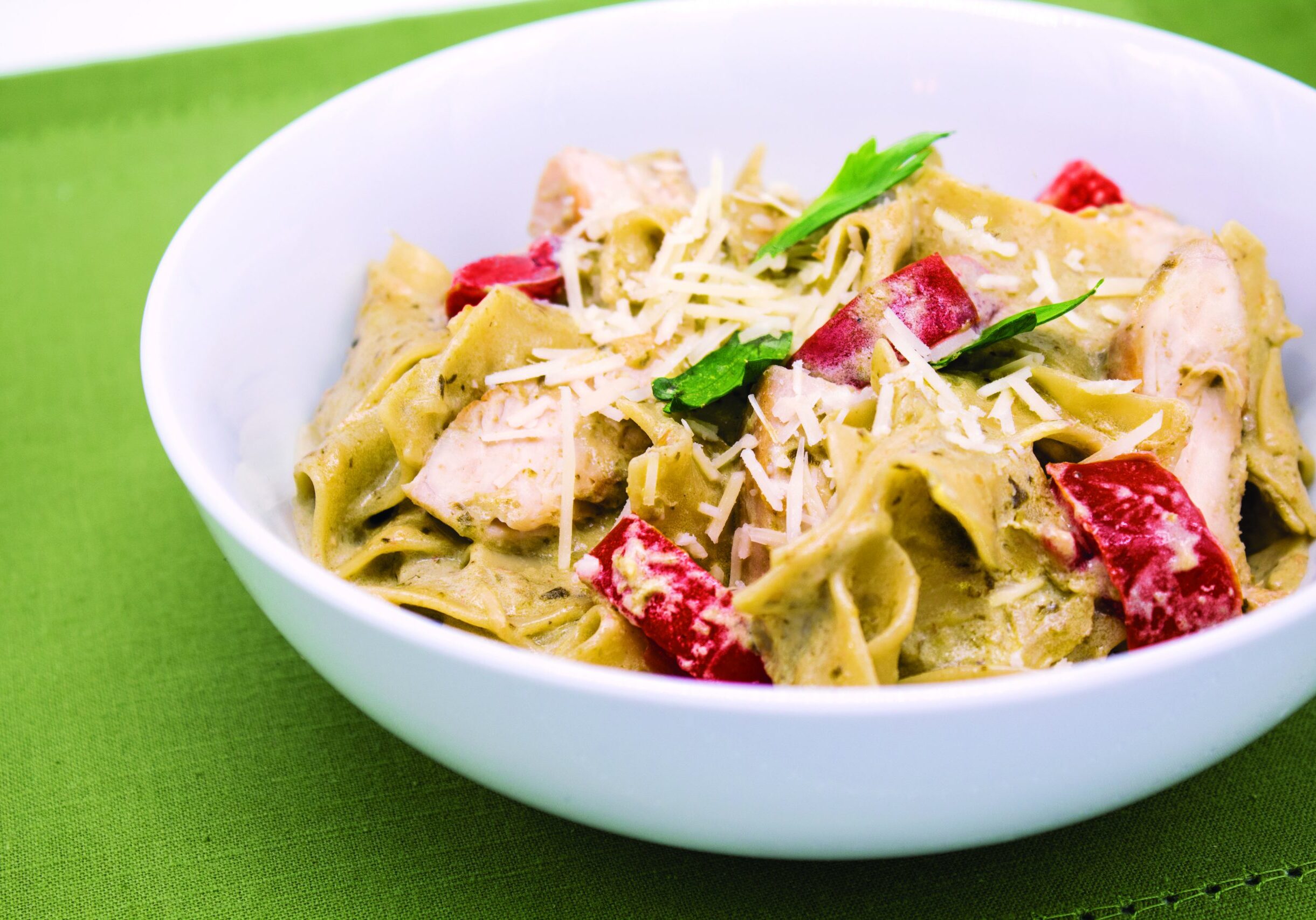 Egg noodles and cubed chicken coated with an Alfredo pesto sauce topped with fresh herbs