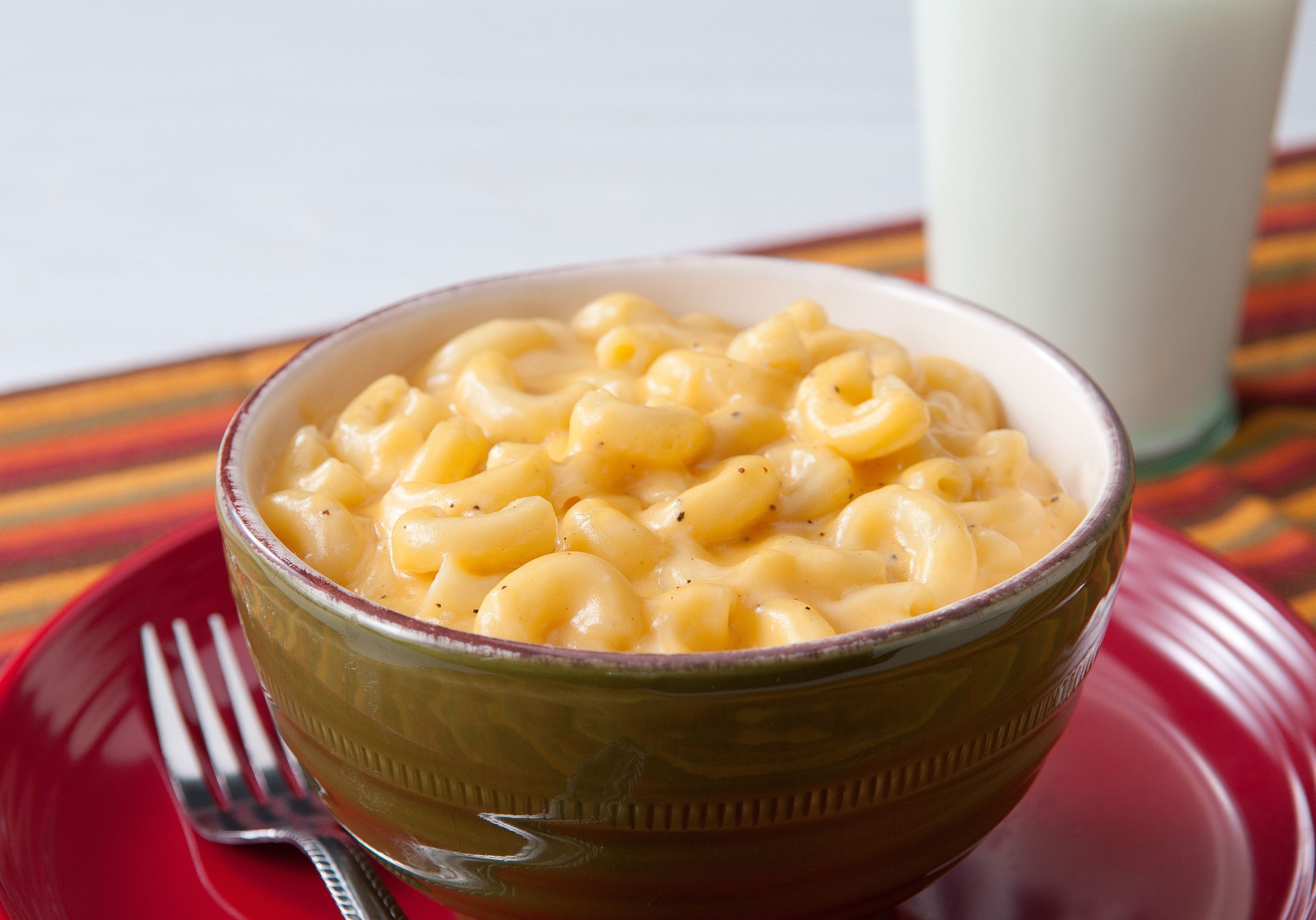 Macaroni noodles in a creamy cheese sauce with a sprinkle of black pepper