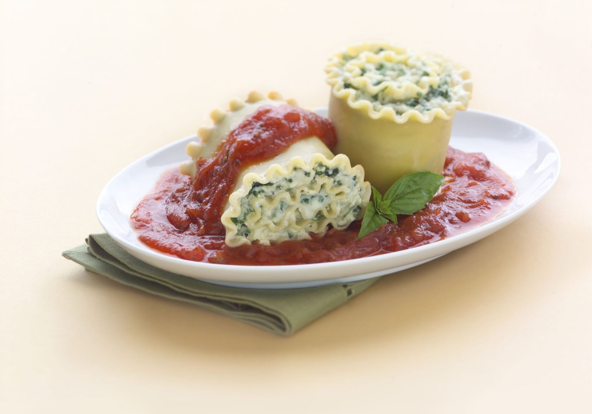 Spinach lasagna rolls stuffed with ricotta and spinach, topped with tomato sauce