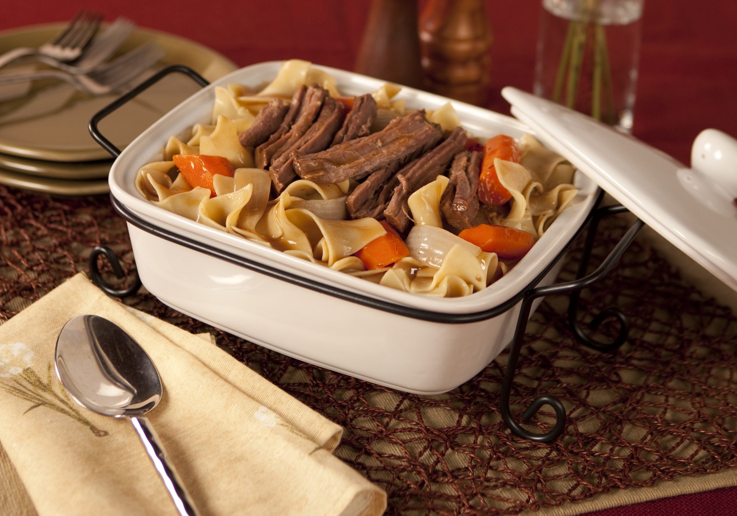 Beef pot roast and wide egg noodles with carrots and onions in a light sauce